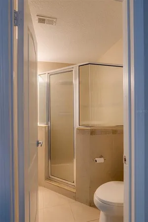 a bathroom with a granite countertop toilet a sink and shower