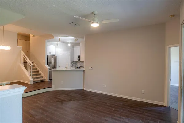 a view of a hallway with wooden floor and kitchen view
