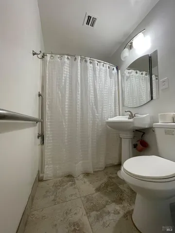 a white toilet sitting next to a shower curtain