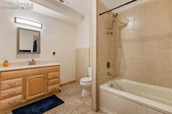 a bathroom with a tub a sink and a large mirror