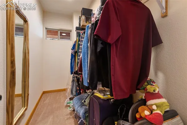 a view of walk in closet with clothes and shoes