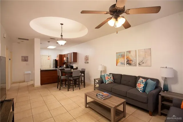 a living room with furniture a dining table and a chandelier