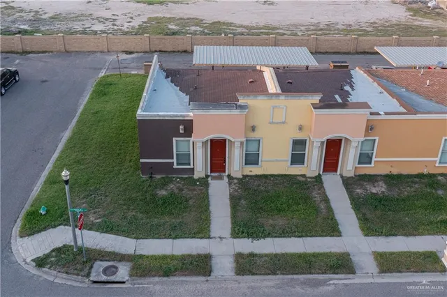 an aerial view of residential houses with outdoor space and parking