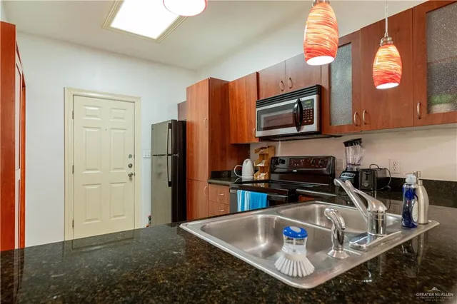 a kitchen with stainless steel appliances granite countertop a sink refrigerator and microwave