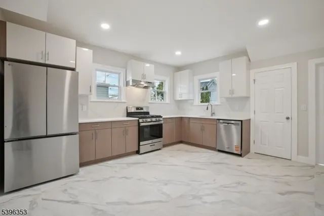 a large kitchen with a refrigerator sink and cabinets