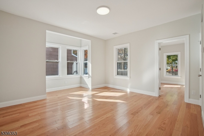 19 Ashwood Avenue, Unit 1 Summit, NJ 07901 - Photo 11 of 17 an empty room with wooden floor and windows