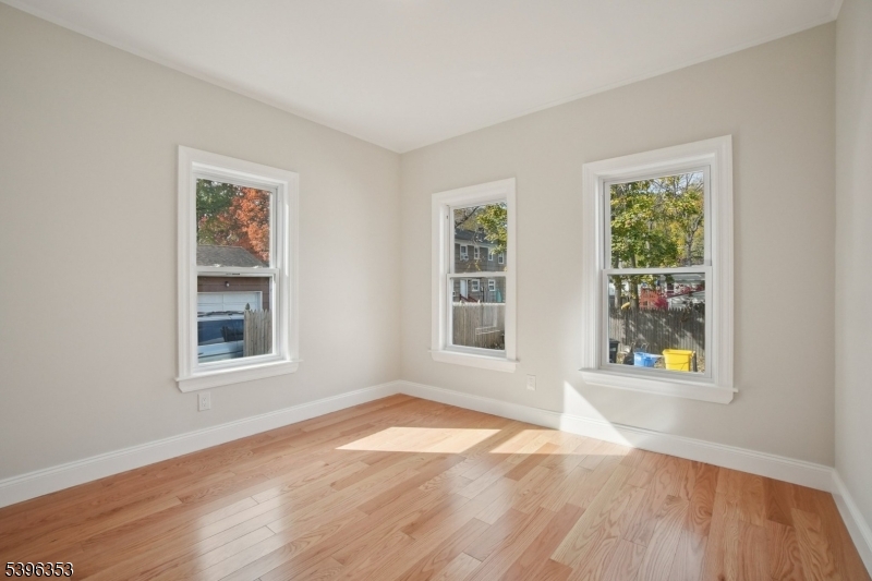 19 Ashwood Avenue, Unit 1 Summit, NJ 07901 - Photo 8 of 17 an empty room with wooden floor and windows