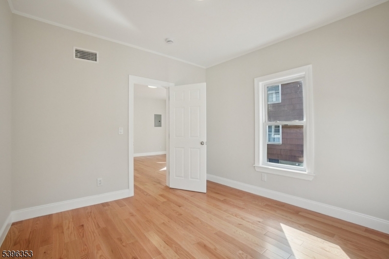 19 Ashwood Avenue, Unit 1 Summit, NJ 07901 - Photo 9 of 17 a view of an empty room with wooden floor and a window