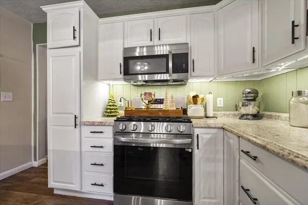 a kitchen with kitchen island granite countertop a sink stainless steel appliances and cabinets