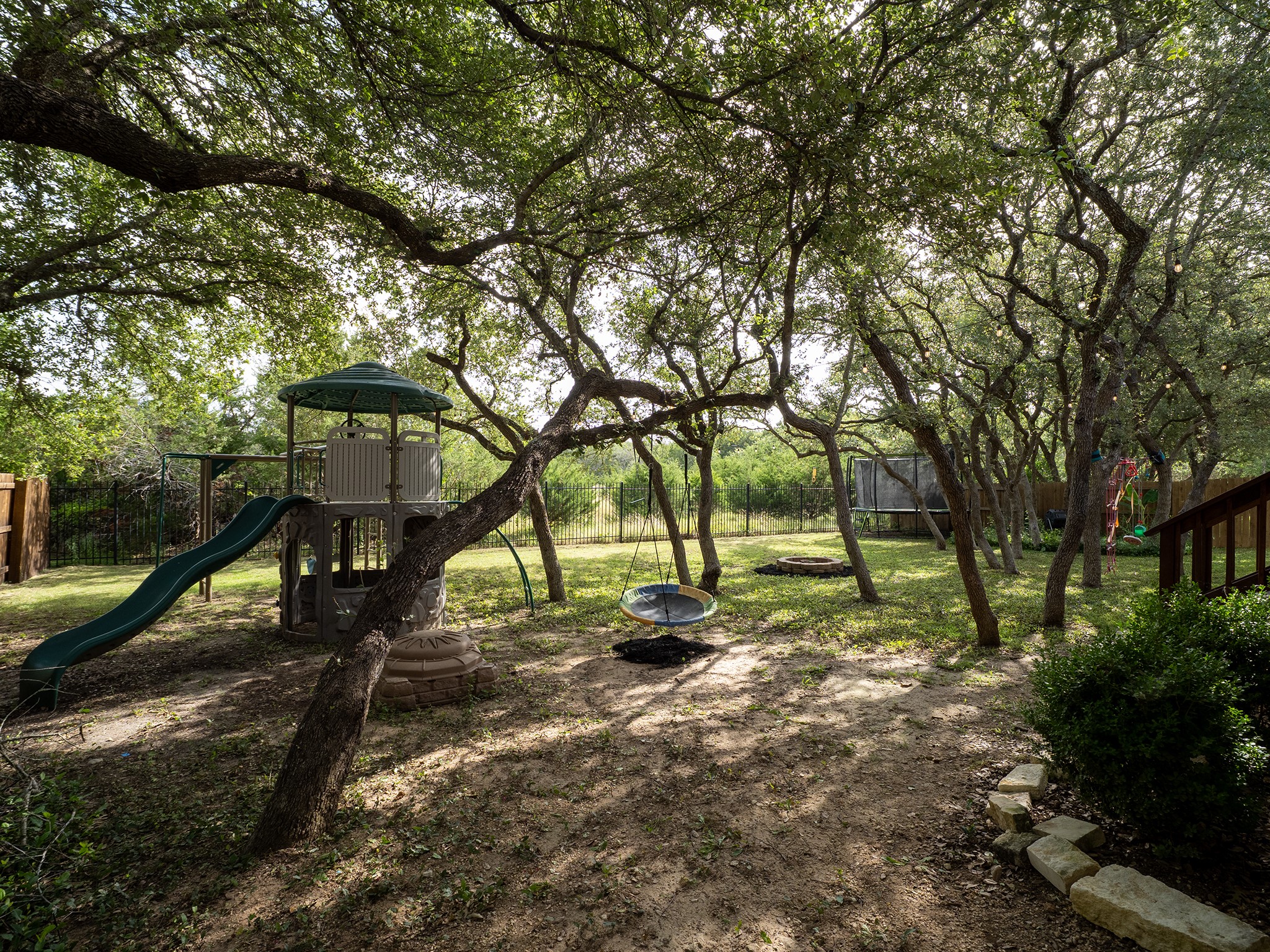 572 Big Meadow Road Austin, TX 78737 - Photo 25 of 32 A spacious backyard retreat offers ample shade with mature trees and a dedicated play area.