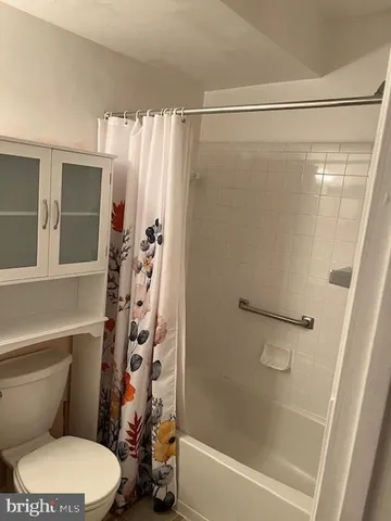 a white toilet sitting next to a bath tub