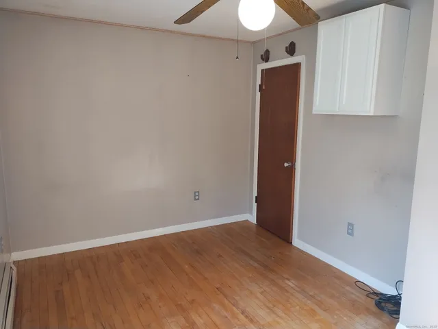 an empty room with wooden floor and closet
