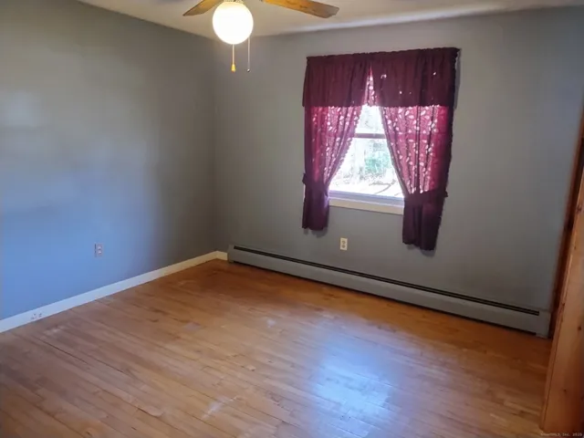 a view of a room with wooden floor and a window