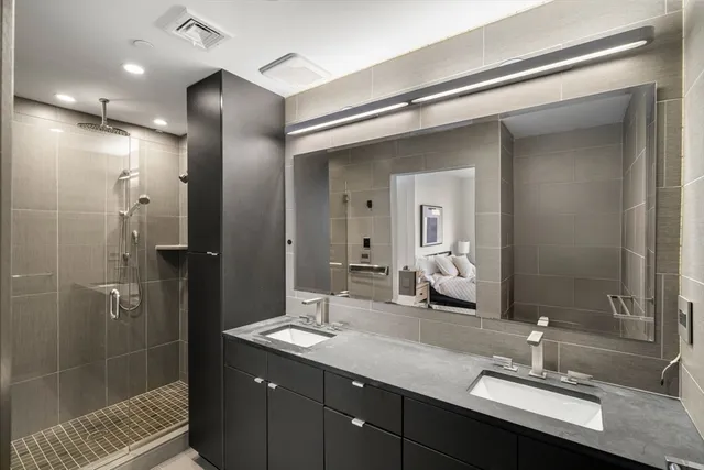 a bathroom with a double vanity sink shower and a mirror