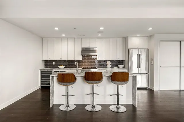 a kitchen with stainless steel appliances granite countertop a refrigerator and a stove top oven
