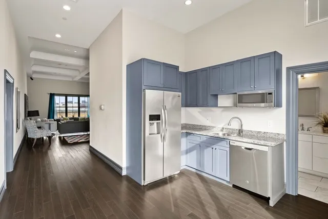 a kitchen with a sink a refrigerator and wooden floor