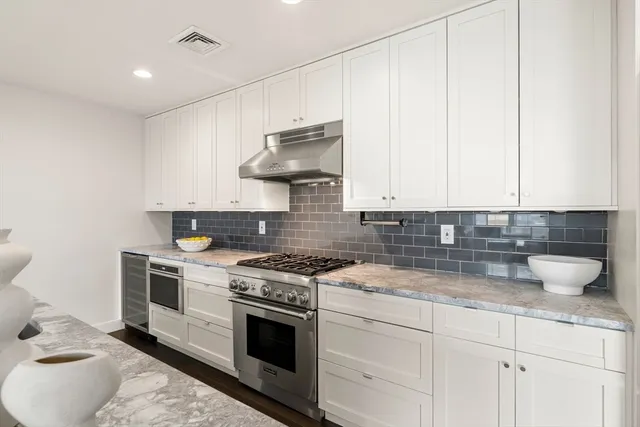 a kitchen with granite countertop a stove and a sink
