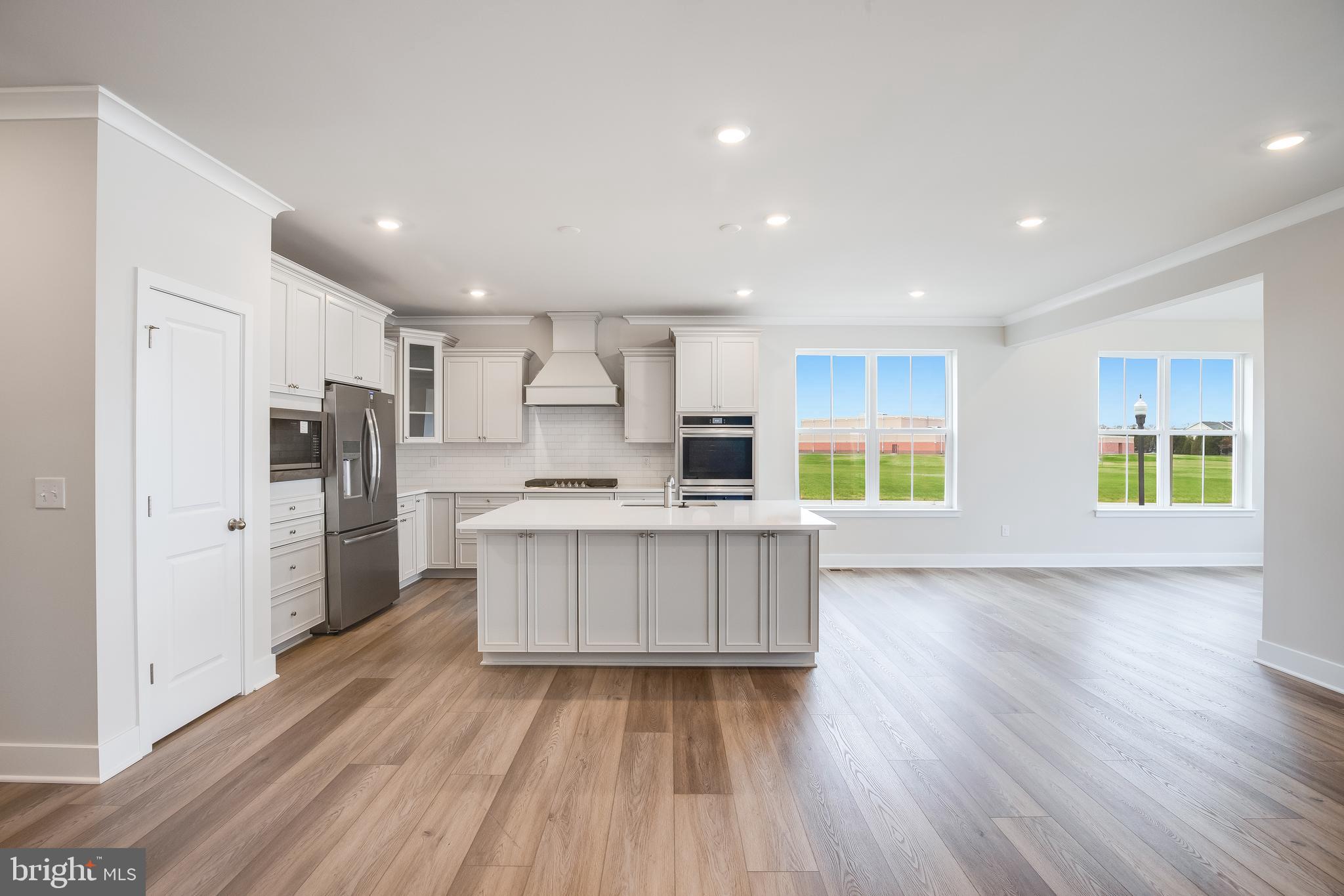 203 Mariners Circle Milton, DE 19968 - Photo 16 of 32 a kitchen with stainless steel appliances a refrigerator and a wooden floor