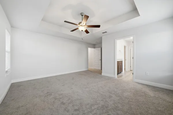 an empty room with chandelier fan
