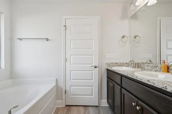 a bathroom with a granite countertop sink a mirror and a bathtub