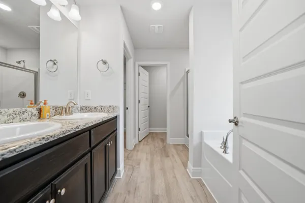 a bathroom with a granite countertop sink a mirror and a bathtub