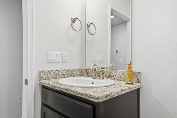 a bathroom with a granite countertop sink and a mirror