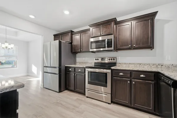 a kitchen with stainless steel appliances granite countertop a stove microwave and refrigerator