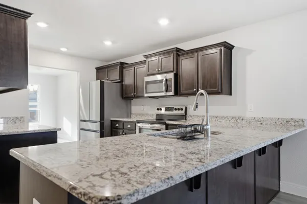 a kitchen with stainless steel appliances granite countertop a sink refrigerator and microwave