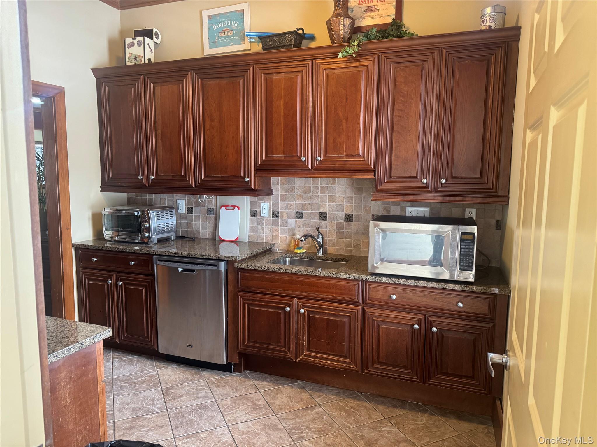 21 High Ridge Lane, Unit 21 Middletown, NY 10940 - Photo 27 of 33 a kitchen with granite countertop wooden cabinets and a sink