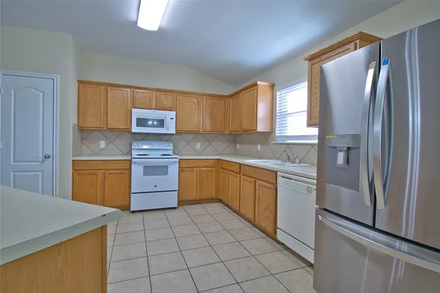 a kitchen with a stove sink and refrigerator