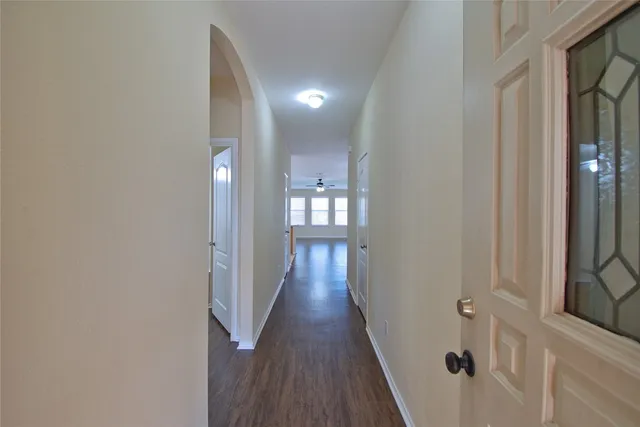 a view of a hallway with wooden floor and a glass door