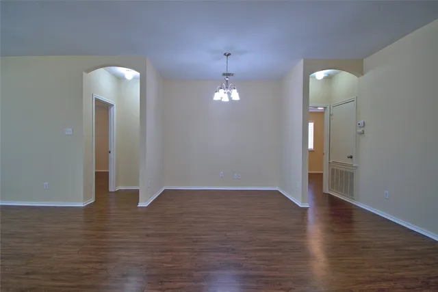 an empty room with wooden floor and mirror