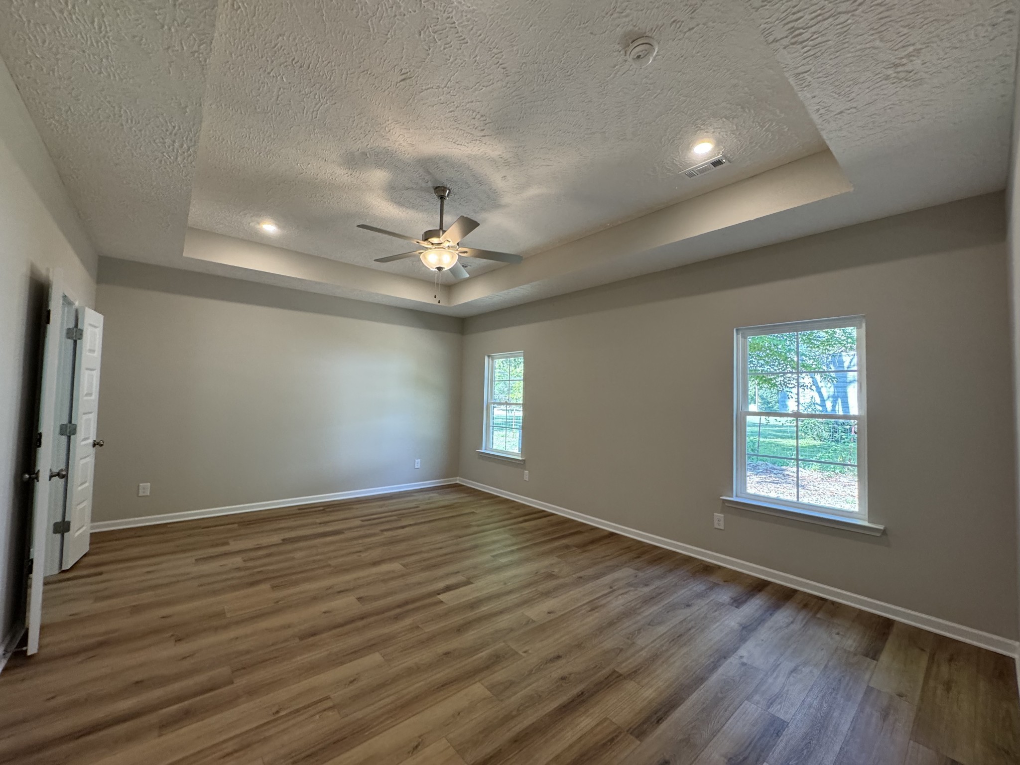 57 Laurel View Street Manchester, TN 37355 - Photo 9 of 23 an empty room with wooden floor chandelier fan and windows