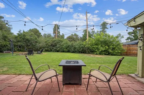 a view of a backyard with table and chairs under an umbrella