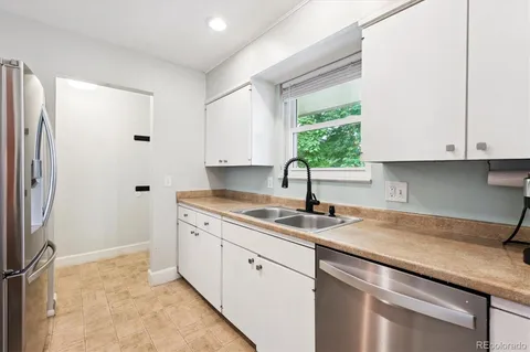 a kitchen with stainless steel appliances granite countertop a sink and a window