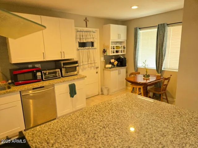 a kitchen with stainless steel appliances a stove a sink and white cabinets