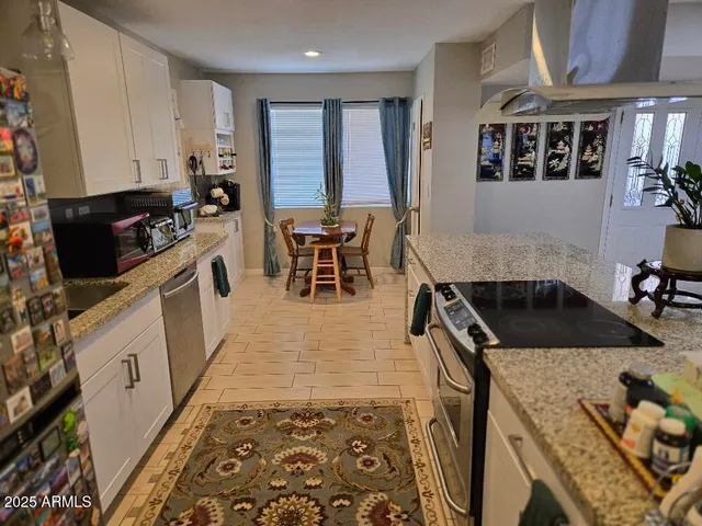 a kitchen with stainless steel appliances granite countertop a stove a sink and a microwave