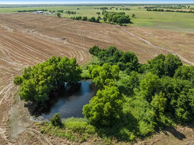 an aerial view of a house with a yard and lake view