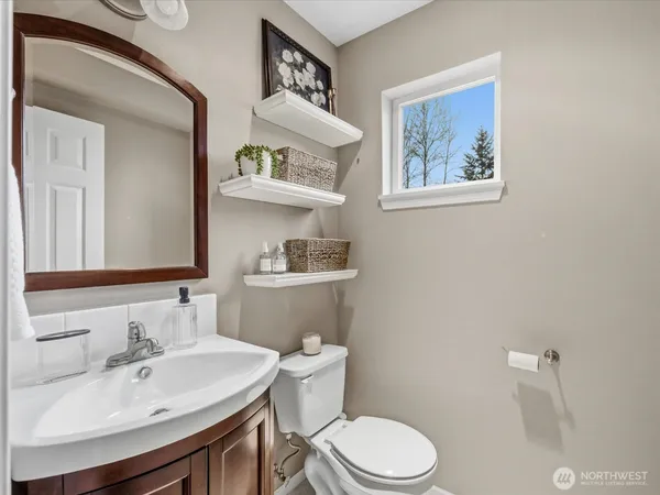 a bathroom with a granite countertop sink a toilet and a mirror