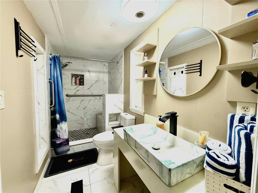 208 Ashley Street Hawthorne, FL 32640 - Photo 18 of 32 a bathroom with a sink a toilet and mirror