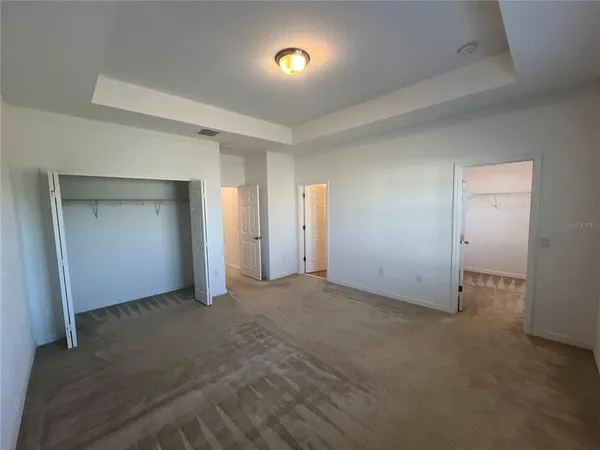 an empty room with closet and windows