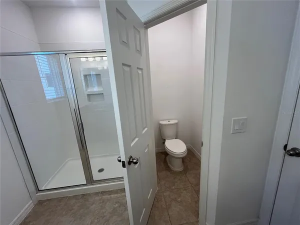 a bathroom with a granite countertop shower and a toilet