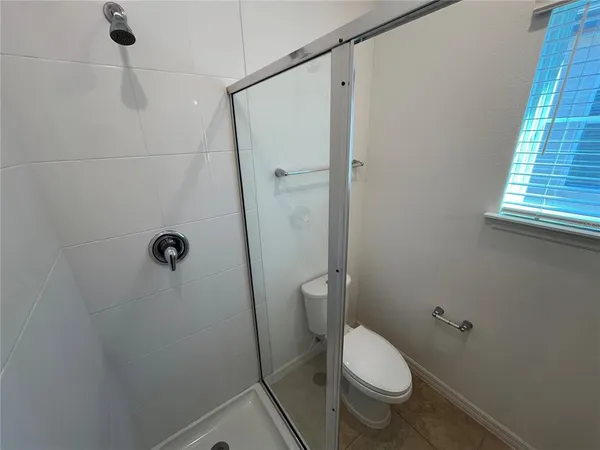 a white toilet sitting next to a shower