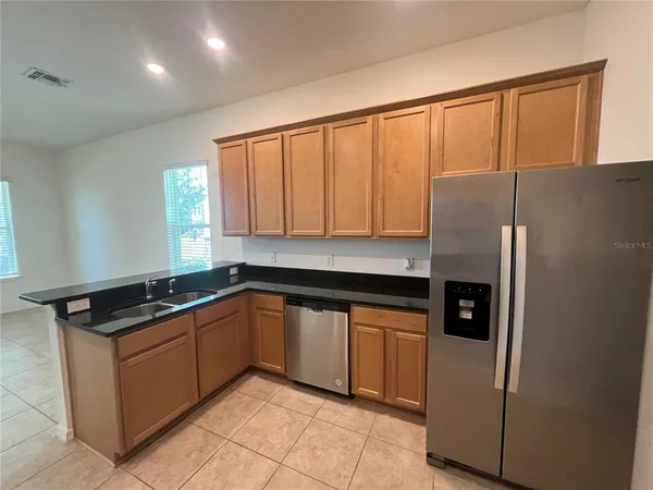 a kitchen with stainless steel appliances granite countertop a refrigerator and a sink