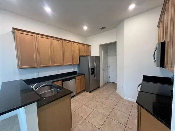 a kitchen with a refrigerator and a stove top oven