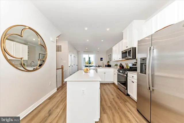 a view of a living room with wooden floor and a fireplace