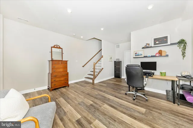 a view of a workspace with furniture and wooden floor