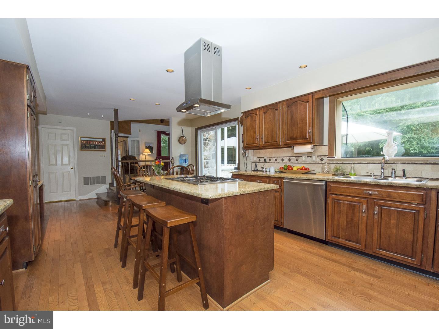 709 South Waterloo Road Devon, PA 19333 - Photo 7 of 25 a kitchen with stainless steel appliances granite countertop a kitchen island a stove a sink a dining table and chairs