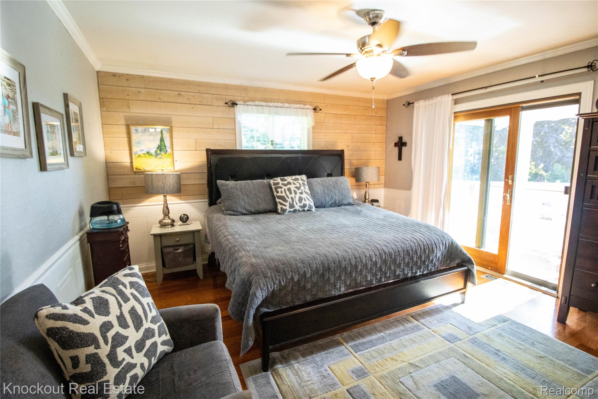 14720 Lincoln Road Chesaning, MI 48616 - Photo 28 of 60 Hardwood-style flooring, wood plank accent wall, ceiling fan with integrated lighting, built-in shelving, and sliding glass door
