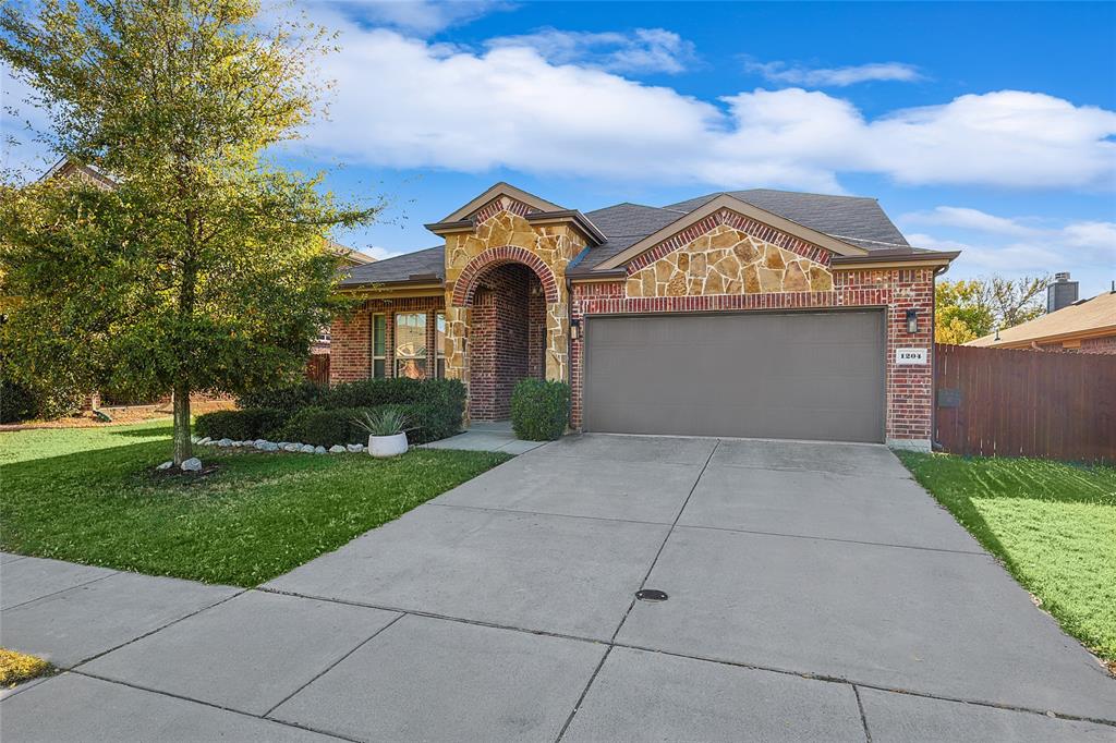 1204 Cheyenne Drive Aubrey, TX 76227 - Photo 1 of 1 View of front facade featuring concrete driveway, an attached garage, a front yard, brick siding, and fence